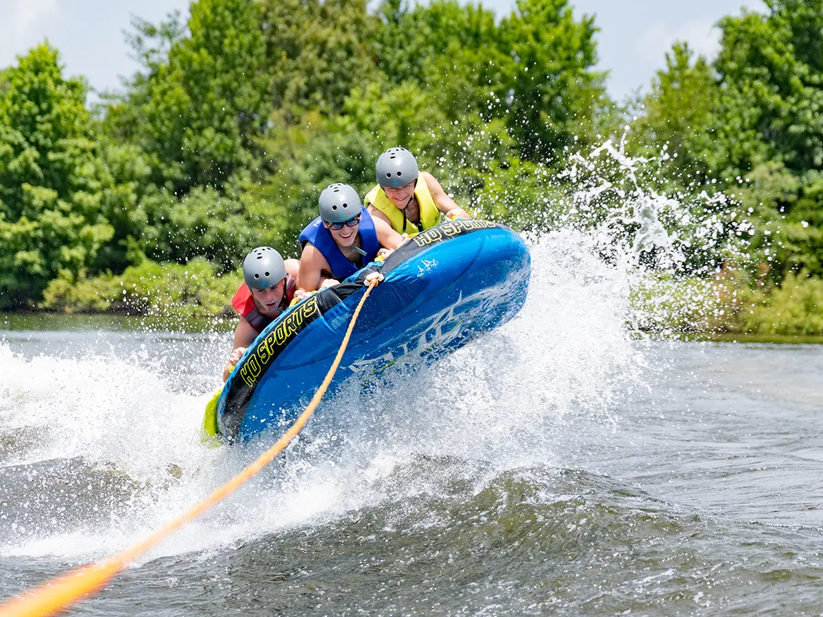 Campers riding an inflatable tube on the Brookhill Ranch lake