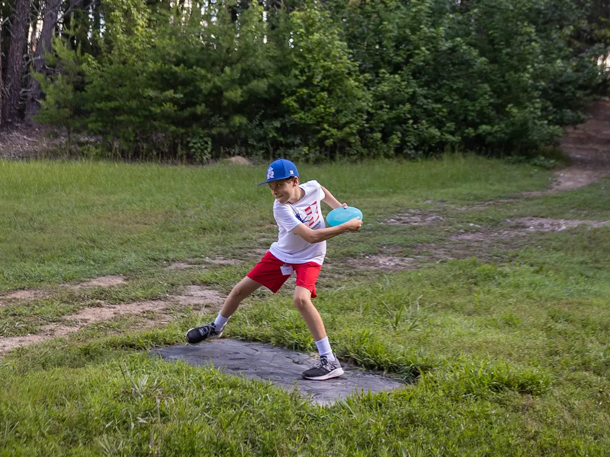 A camper playing disc golf at Brookhill Ranch